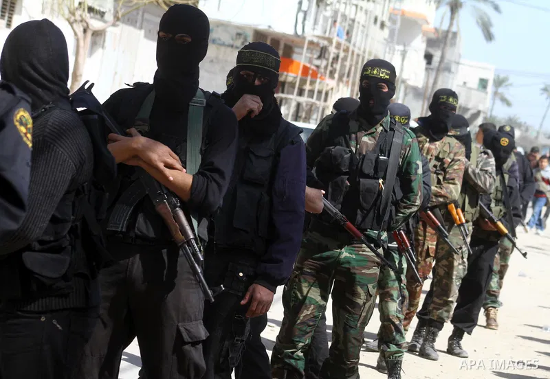 Masked Islamic Jihad militants wait next to the family house of Abeed Shaheen, killed by Israeli shell on Sunday, in Deir al-Balah refugee camp, central Gaza Strip, Monday, Feb. 28, 2011. Photo by Ashraf Amra
