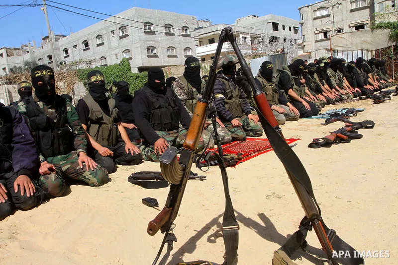 Masked Islamic Jihad militants wait next to the family house of Abeed Shaheen, killed by Israeli shell on Sunday, in Deir al-Balah refugee camp, central Gaza Strip, Monday, Feb. 28, 2011. Photo by Ashraf Amra