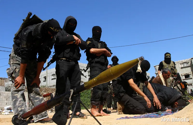 Masked Islamic Jihad militants wait next to the family house of Abeed Shaheen, killed by Israeli shell on Sunday, in Deir al-Balah refugee camp, central Gaza Strip, Monday, Feb. 28, 2011. Photo by Ashraf Amra