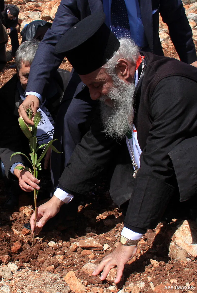 A Palestinian christian, George Awad Alartdhuks helps farmers to plant olive trees during a protest against the uprooting of trees belonging to Palestinians by Jewish settlers near the settlement of Elon Moreh in the Wes...