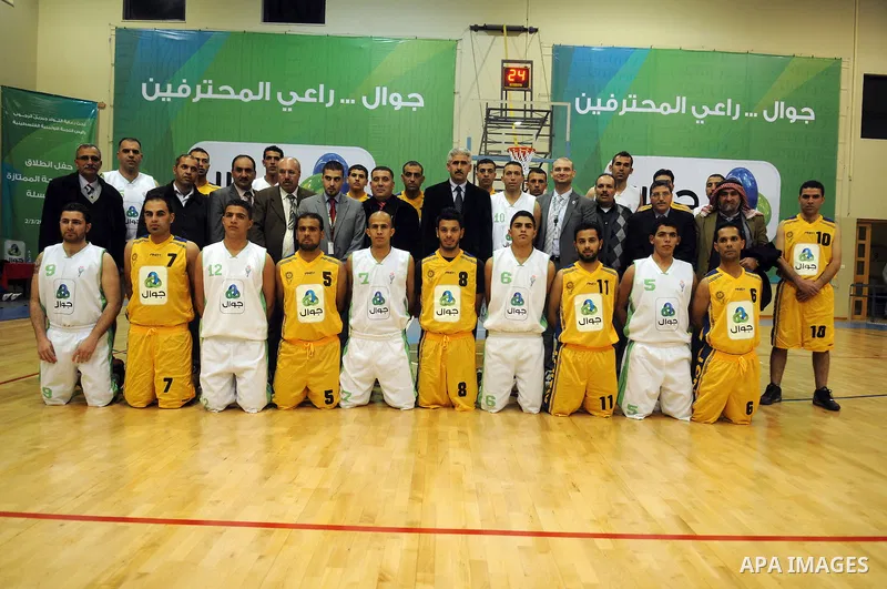 Palestinian basketball players pose for photographs after a basketball game between Abdaa team and Alfaraa team during opening of Premier League for basketball, in the West Bank City of Bethlehem on March 02, 2011. Photo...