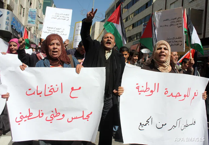 Palestinian protestors hold national flags and banners during a rally against the U.S. veto and calling for the national reconciliation, in the West Bank city of Hebron, on March 03, 2011. Photo by Najeh Hashlamoun