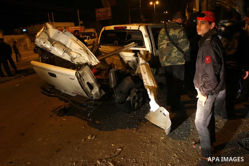 Palestinians inspect a car damaged by an Israeli airstrike, in the central Gaza Strip, March 4, 2011. Palestinian official said that Israeli aircraft struck a car on Friday with no injures.. Photo by Ashraf Amra