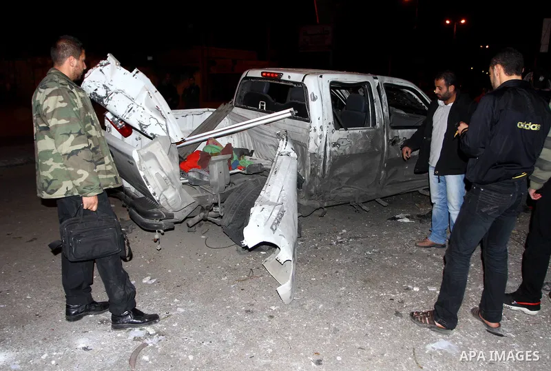 Palestinians inspect a car damaged by an Israeli airstrike, in the central Gaza Strip, March 4, 2011. Palestinian official said that Israeli aircraft struck a car on Friday with no injures.. Photo by Ashraf Amra