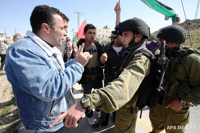 Protesters argue with an Israeli soldier during a demonstration against Israel's controversial separation barrier in the West Bank village of Maasarah, near the biblical town of Bethlehem on March 04, 2011.Israel says th...