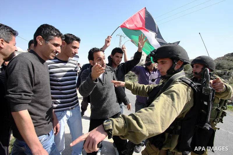 Protesters argue with an Israeli soldier during a demonstration against Israel's controversial separation barrier in the West Bank village of Maasarah, near the biblical town of Bethlehem on March 04, 2011.Israel says th...