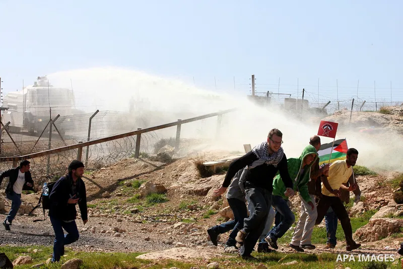 A Palestinian youth hurls a stone at Israeli soldiers during a protest against Israel's controversial separation barrier in the village of Bilin, near the West Bank city of Ramallah, in the Israeli occupied West Bank, on...