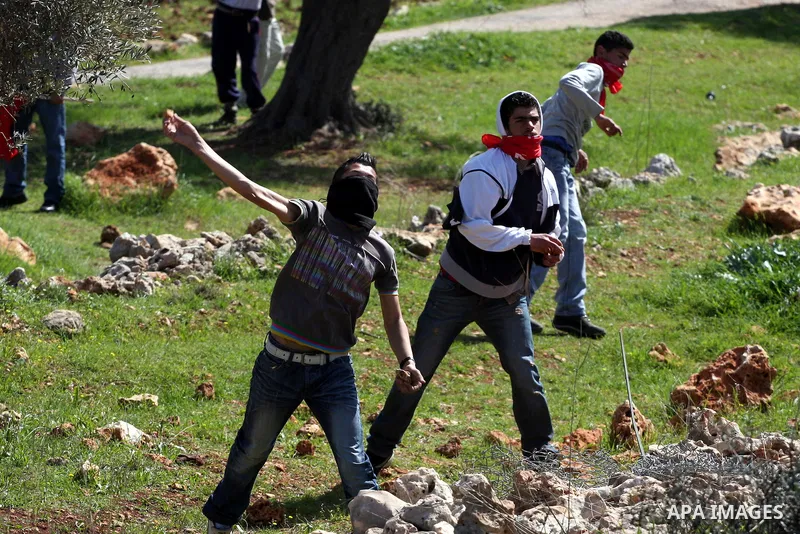 A Palestinian youth hurls a stone at Israeli soldiers during a protest against Israel's controversial separation barrier in the village of Bilin, near the West Bank city of Ramallah, in the Israeli occupied West Bank, on...