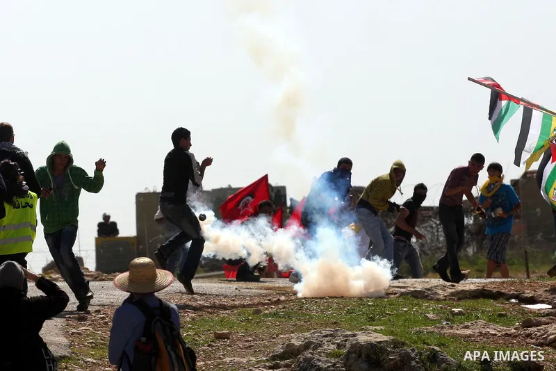 A Palestinian youth hurls a stone at Israeli soldiers during a protest against Israel's controversial separation barrier in the village of Bilin, near the West Bank city of Ramallah, in the Israeli occupied West Bank, on...