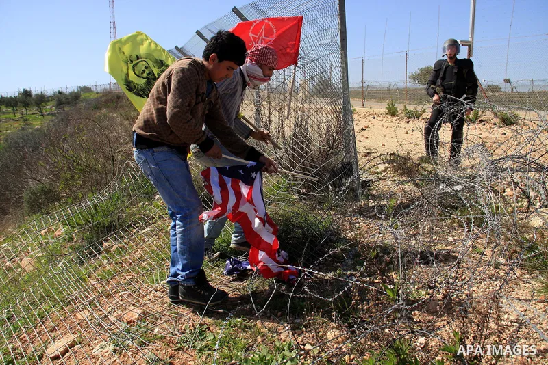 A Palestinian protester burns a U.S. flag during a protest against the construction of Israel's separation barrier in the West Bank village of Bilin near Ramallah, Friday,March 4, 2011. Photo by Wagdi Eshtayah