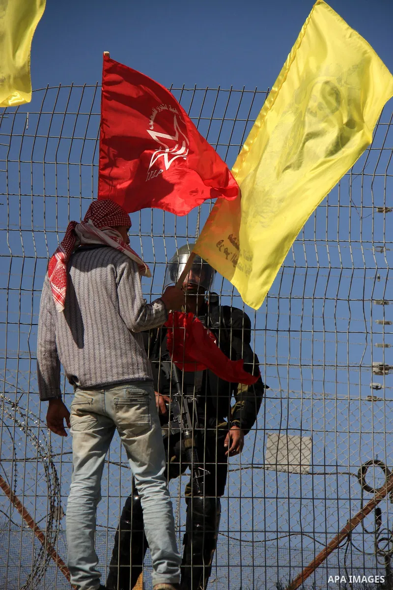 Palestinian demonstrators holds Palestinian flags during a protestagainst the construction of Israel's separation barrier in the West Bank village of Bilin near Ramallah, Friday,March 4, 2011. Photo by Wagdi Eshtayah