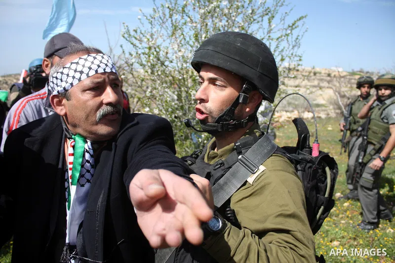 Israeli soldiers throw a stun grenade and fire tear gas towards Palestinian ,Israelian and International protesters during a demonstration against the demolishing of farm land to be used in the construction of Jewish set...