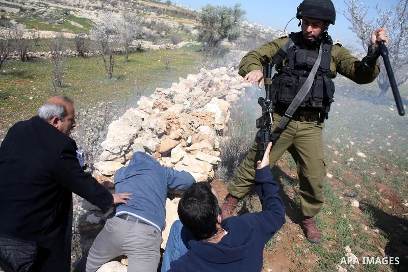 Israeli soldiers throw a stun grenade and fire tear gas towards Palestinian ,Israelian and International protesters during a demonstration against the demolishing of farm land to be used in the construction of Jewish set...