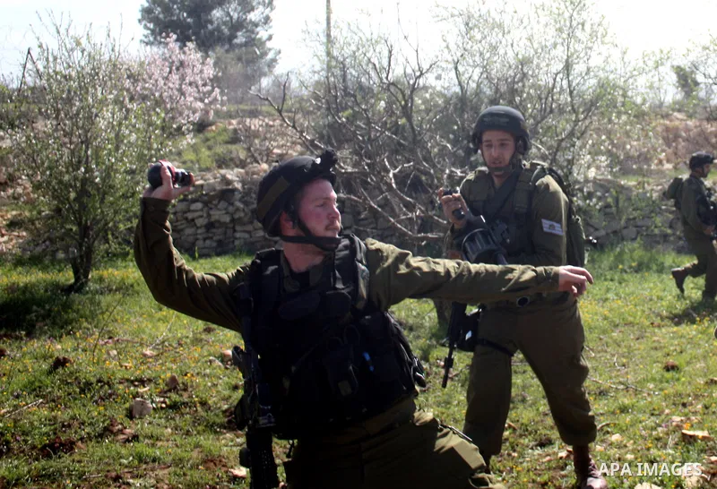 Israeli soldiers throw a stun grenade and fire tear gas towards Palestinian ,Israelian and International protesters during a demonstration against the demolishing of farm land to be used in the construction of Jewish set...