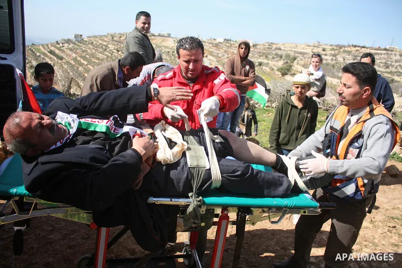 A Palestinian man receives treatment during a demonstration by Palestinian ,Israeli and International protesters against the demolishing of farm land to be used in the construction of Jewish settlements near the existing...