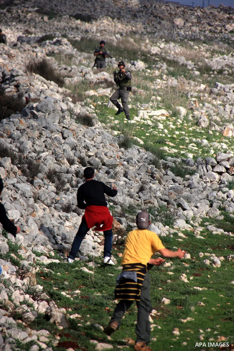 Palestinian protestors hurl stones at Israeli troops, in the West Bank village of Iraq Burin, near Nablus,Saturday , March 5, 2011... Photo by Wagdi Eshtayah