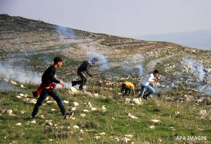Palestinian demonstrators run to seek cover from tear gas fired by Israeli soldiers in the West Bank village of Iraq Borin near Nablus, on 05 March 2011. Two Palestinians were wounded after Israeli troops raided the vill...