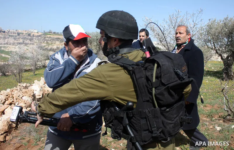 Israeli soldiers throw a stun grenade and fire tear gas towards Palestinian ,Israelian and International protesters during a demonstration against the demolishing of farm land to be used in the construction of Jewish set...