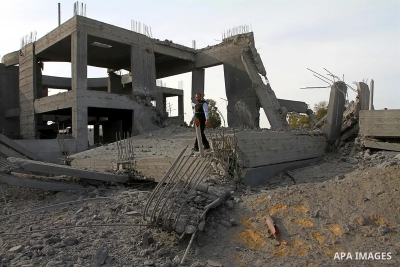 A Palestinian man inspects the damage to a building still under construction and belonging to the Islamic University, following an overnight Israeli air raid, south of Gaza City, on March 6, 2011. Photo by Ashraf Amra