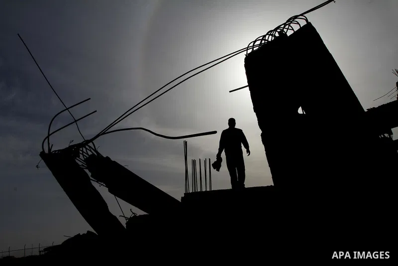 A Palestinian man inspects the damage to a building still under construction and belonging to the Islamic University, following an overnight Israeli air raid, south of Gaza City, on March 6, 2011. Photo by Ashraf Amra