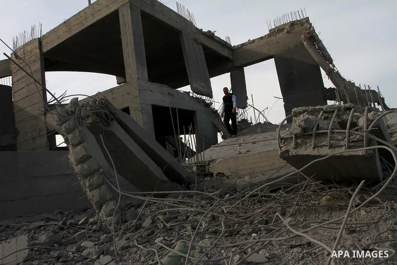 A Palestinian man inspects the damage to a building still under construction and belonging to the Islamic University, following an overnight Israeli air raid, south of Gaza City, on March 6, 2011. Photo by Ashraf Amra