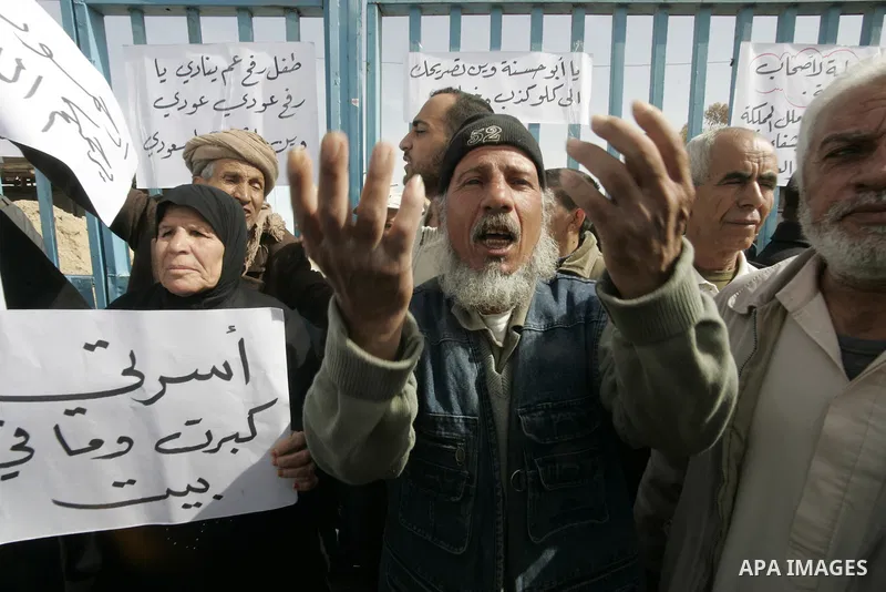 Palestinians protest outside the UNRWA headquarters in the southern Gaza Strip Rafah refugee camp on March 6, 2011, calling for implementation of the United Nations decision to construct the houses which were destroyed d...