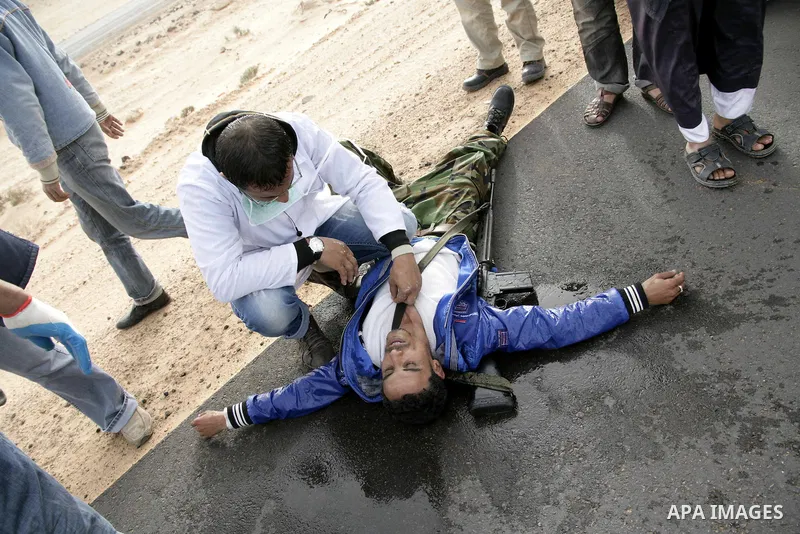 Rebel fighters take cover from shelling by soldiers loyal to Libyan leader Muammar Gaddafi during a battle near Ras Lanuf, March 4, 2011. Heavily armed rebels clashed with forces loyal to Gaddafi on Friday on the outskir...