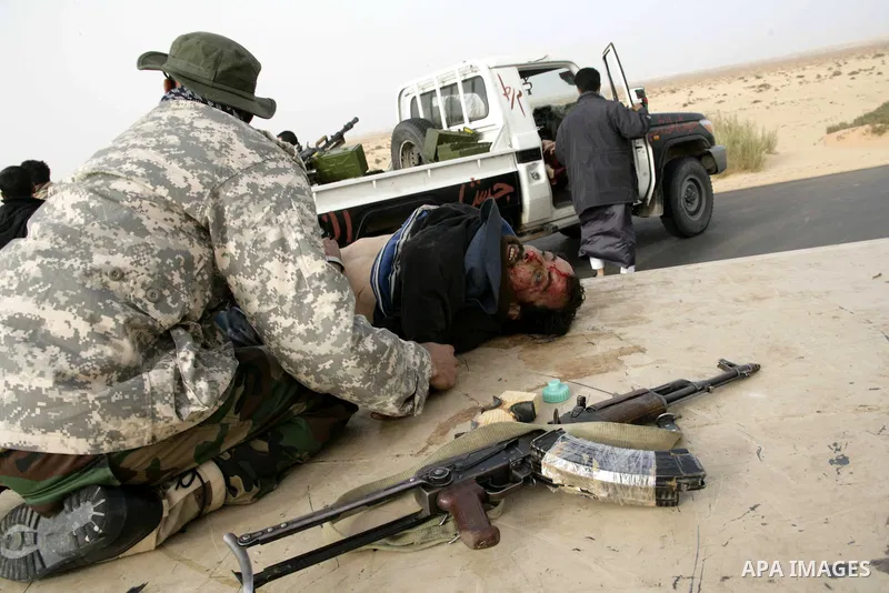 Rebel fighters take cover from shelling by soldiers loyal to Libyan leader Muammar Gaddafi during a battle near Ras Lanuf, March 4, 2011. Heavily armed rebels clashed with forces loyal to Gaddafi on Friday on the outskir...
