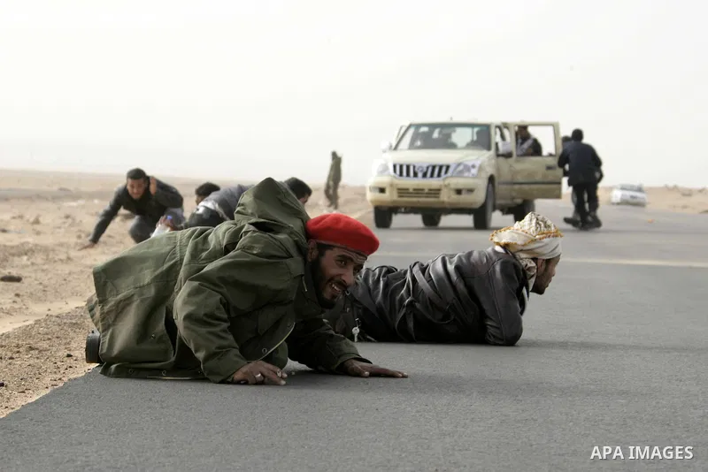 Rebel fighters take cover from shelling by soldiers loyal to Libyan leader Muammar Gaddafi during a battle near Ras Lanuf, March 4, 2011. Heavily armed rebels clashed with forces loyal to Gaddafi on Friday on the outskir...