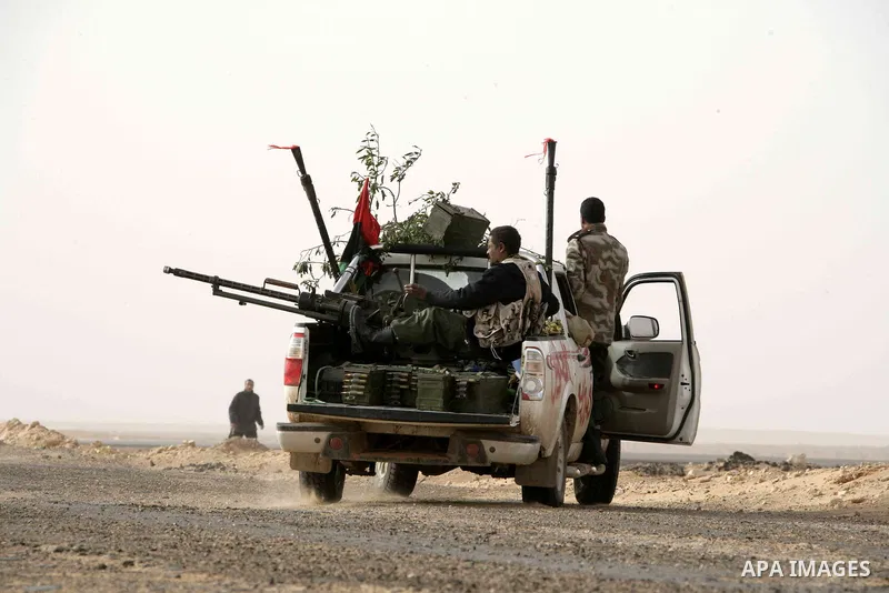 Rebel fighters return fire during shelling by soldiers loyal to Libyan leader Muammar Gaddafi in a battle near Ras Lanuf, March 4, 2011. Heavily armed rebels clashed with forces loyal to Gaddafi on Friday on the outskirt...