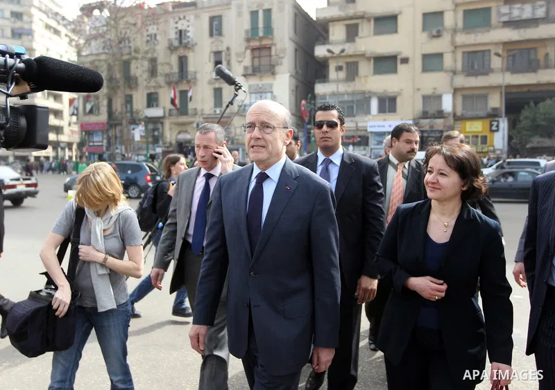 French newly appointed Foreign Minister Alain Juppe (C) walks on Cairo's Tahrir square on March 6, 2011 as part of a visit during which he affirmed his country's commitment to Egypt. Juppe, speaking to the French communi...