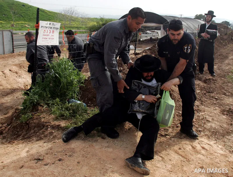 Israeli policeman arresting an ultra Orthodox during a protest against dig tombs in Haifa, on march 6, 2011. Photo by Mahfouz Abu Turk