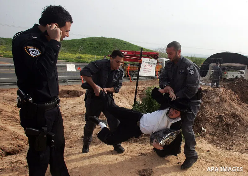 Israeli policeman arresting an ultra Orthodox during a protest against dig tombs in Haifa, on march 6, 2011. Photo by Mahfouz Abu Turk