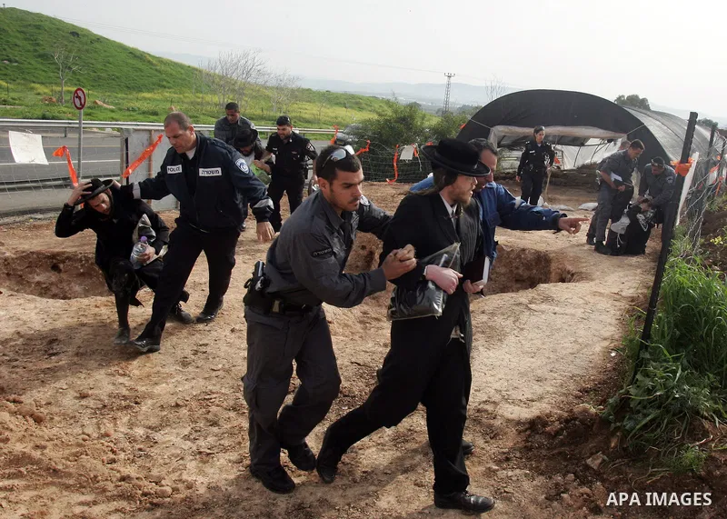 Israeli policeman arresting an ultra Orthodox during a protest against dig tombs in Haifa, on march 6, 2011. Photo by Mahfouz Abu Turk