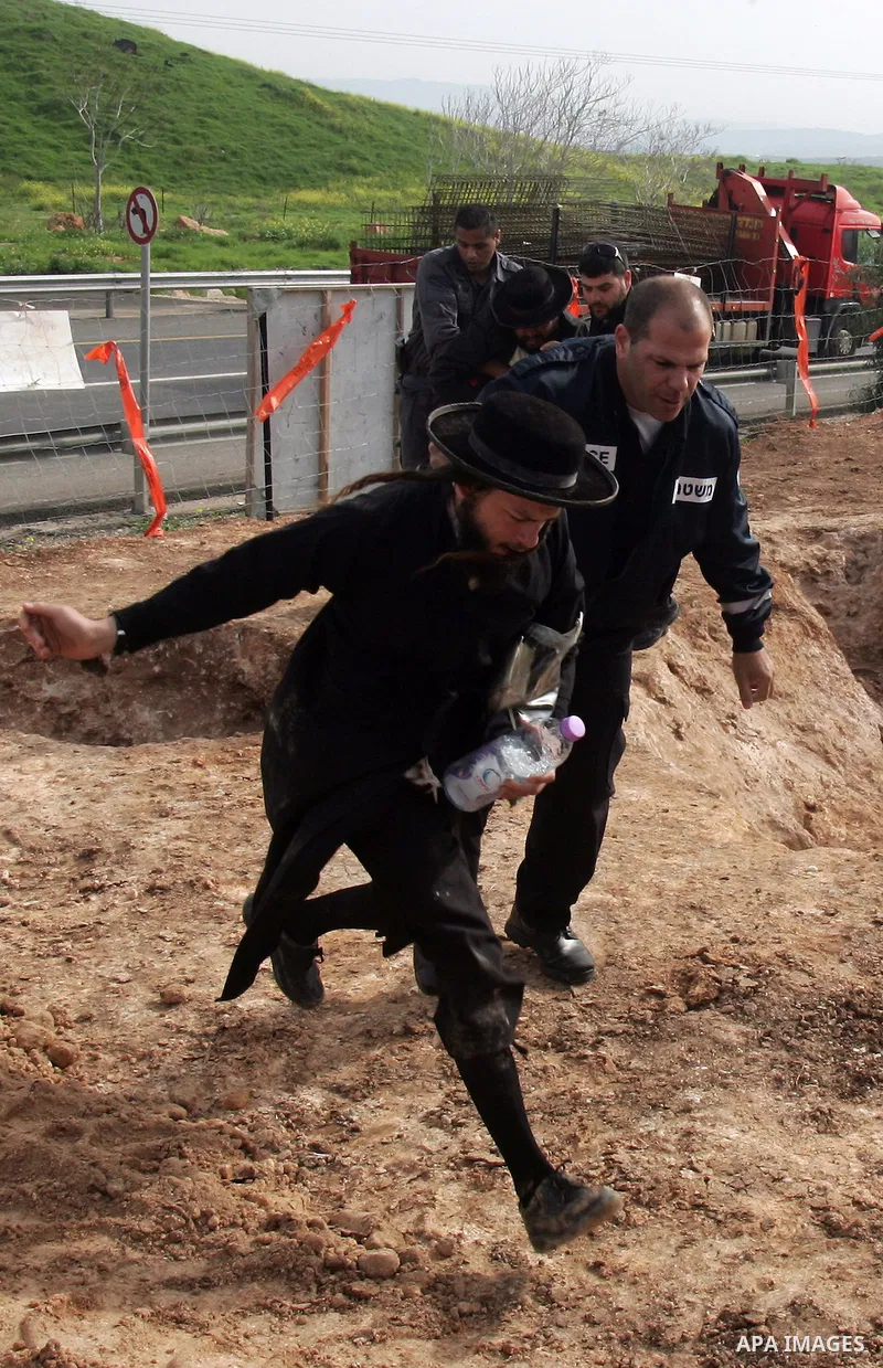 Israeli policeman arresting an ultra Orthodox during a protest against dig tombs in Haifa, on march 6, 2011. Photo by Mahfouz Abu Turk