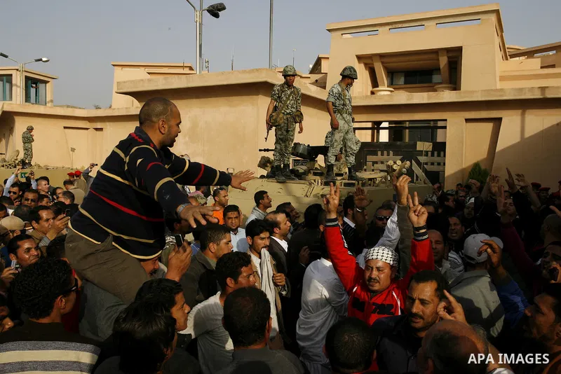 Egyptian protesters chant slogans during a demonstration in front of an Egyptian state security building in the outskirts of Cairo on Mach 5, 2011 while state security employees briefly fired gunshots as hundreds of prot...