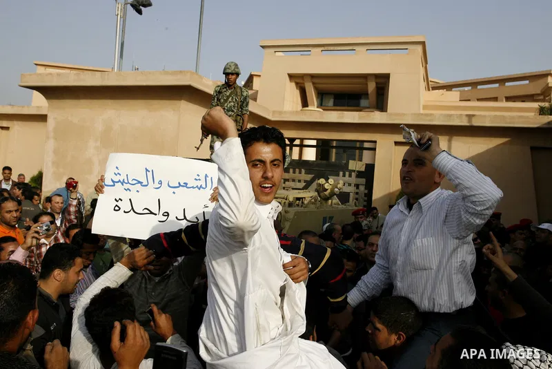 Egyptian protesters chant slogans during a demonstration in front of an Egyptian state security building in the outskirts of Cairo on Mach 5, 2011 while state security employees briefly fired gunshots as hundreds of prot...