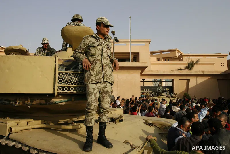 Egyptian protesters chant slogans during a demonstration in front of an Egyptian state security building in the outskirts of Cairo on Mach 5, 2011 while state security employees briefly fired gunshots as hundreds of prot...