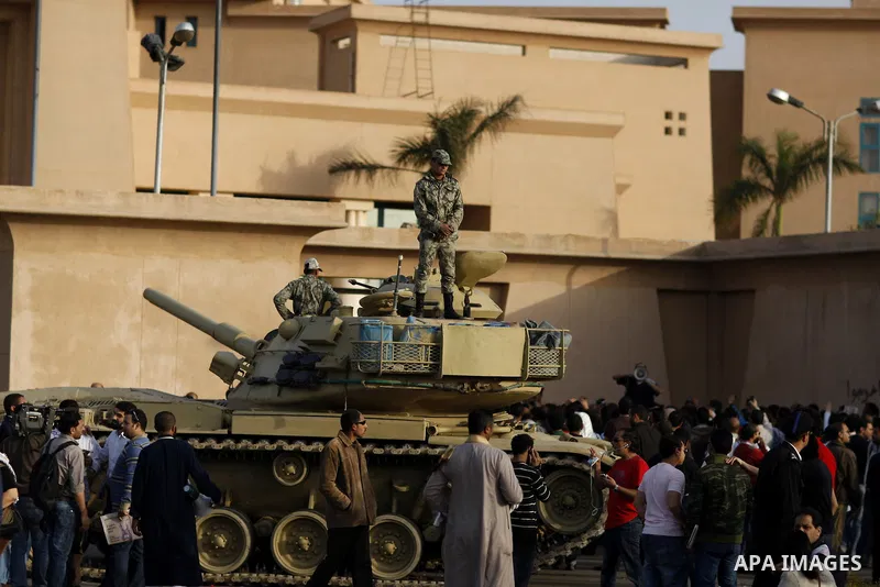 Egyptian protesters chant slogans during a demonstration in front of an Egyptian state security building in the outskirts of Cairo on Mach 5, 2011 while state security employees briefly fired gunshots as hundreds of prot...