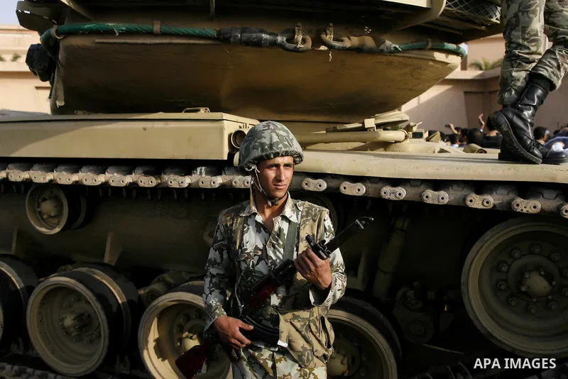 Egyptian protesters chant slogans during a demonstration in front of an Egyptian state security building in the outskirts of Cairo on Mach 5, 2011 while state security employees briefly fired gunshots as hundreds of prot...