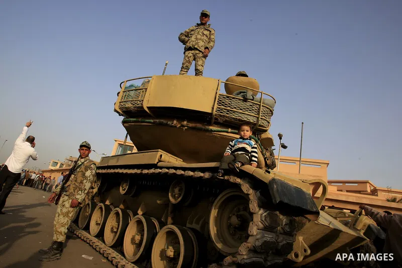 Egyptian protesters chant slogans during a demonstration in front of an Egyptian state security building in the outskirts of Cairo on Mach 5, 2011 while state security employees briefly fired gunshots as hundreds of prot...