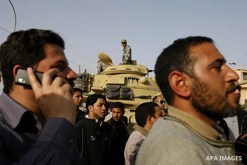 Egyptian protesters chant slogans during a demonstration in front of an Egyptian state security building in the outskirts of Cairo on Mach 5, 2011 while state security employees briefly fired gunshots as hundreds of prot...