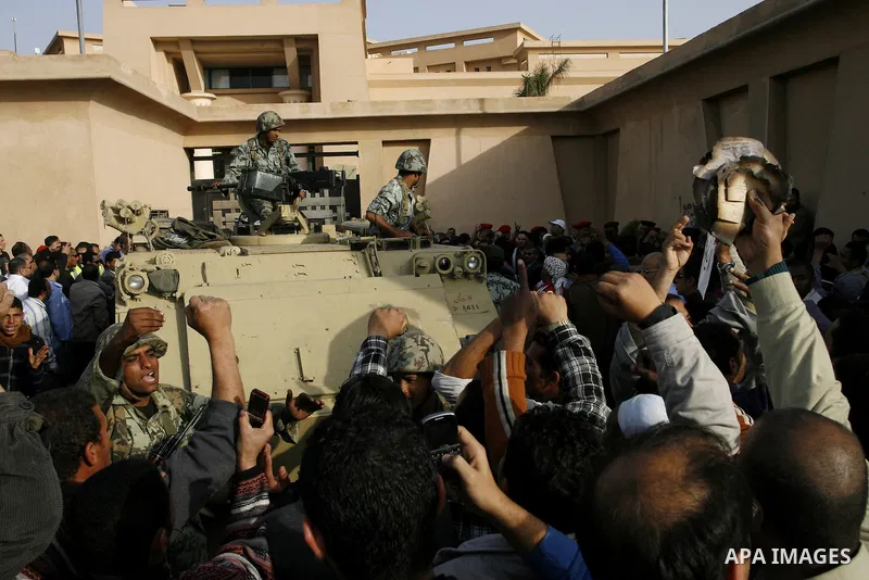 Egyptian protesters chant slogans during a demonstration in front of an Egyptian state security building in the outskirts of Cairo on Mach 5, 2011 while state security employees briefly fired gunshots as hundreds of prot...