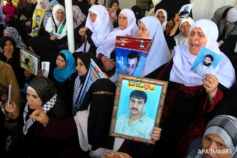 Palestinian women hold pictures of jailed relatives during a protest calling for the release of Palestinian prisoners from Israeli jails at the Red Cross office in Gaza City on March. 7,2011. Photo by Ashraf Amra