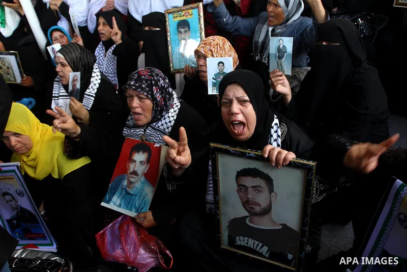 Palestinian women hold pictures of jailed relatives during a protest calling for the release of Palestinian prisoners from Israeli jails at the Red Cross office in Gaza City on March. 7,2011. Photo by Ashraf Amra