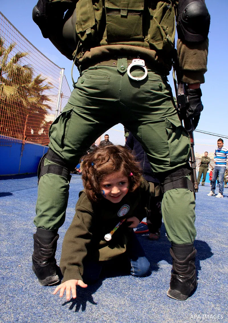 Palestinian security officers play with school children during a celebration in the West Bank city of Nablus, Monday, March 7, 2011. Photo by Wagdi Eshtayah