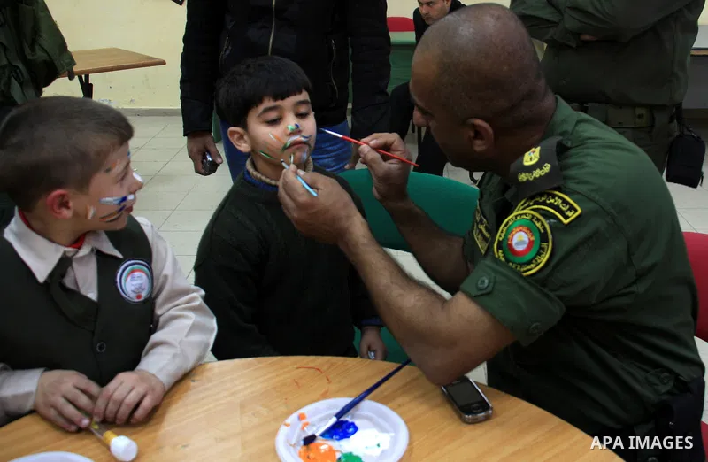 Palestinian security officers play with school children during a celebration in the West Bank city of Nablus, Monday, March 7, 2011. Photo by Wagdi Eshtayah