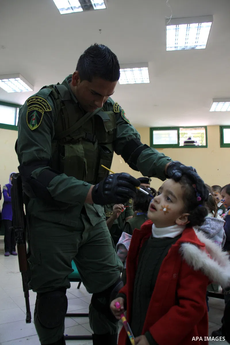 Palestinian security officers play with school children during a celebration in the West Bank city of Nablus, Monday, March 7, 2011. Photo by Wagdi Eshtayah