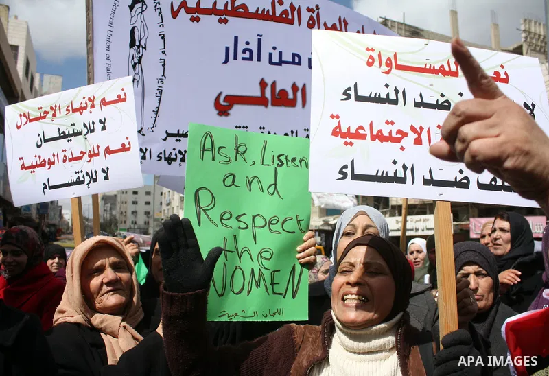 Palestinian women hold placards to mark the International Women Day in the West Bank city of Hebron, on March 08 2011.Photo by Najeh Hashlamoun
