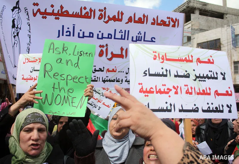 Palestinian women hold placards to mark the International Women Day in the West Bank city of Hebron, on March 08 2011.Photo by Najeh Hashlamoun